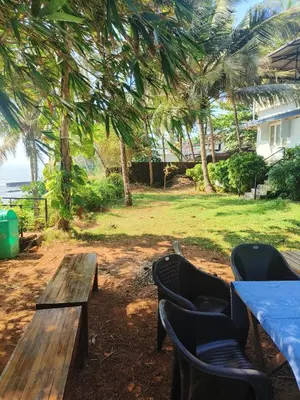 a picnic table and chairs with a view of the ocean at Perch by the sea 2 in Kannur