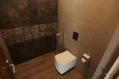 a small bathroom with a toilet and a shower at Mon Reve - Home in the valley in Puthuppādi