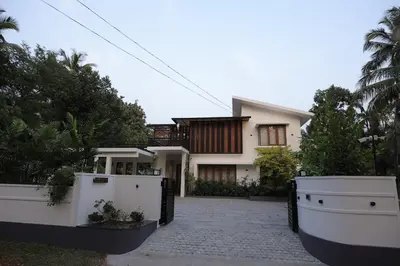 a white house with a gate in front of it at Mon Reve - Home in the valley in Puthuppādi