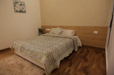 a bedroom with a bed and a wooden floor at Mon Reve - Home in the valley in Puthuppādi
