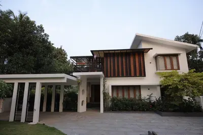 a white house with a balcony on top of it at Mon Reve - Home in the valley in Puthuppādi