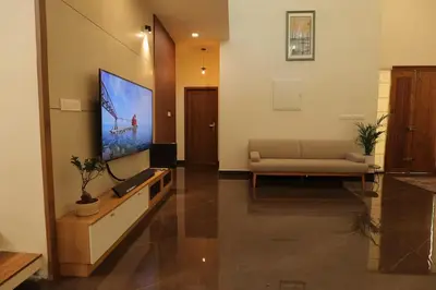 a living room with a couch and a flat screen tv at Mon Reve in Kozhikode