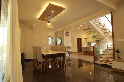 a dining room and kitchen with a table and chairs at Mon Reve in Kozhikode