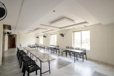 a group of tables and chairs in a room at Parva Residency in Palladam