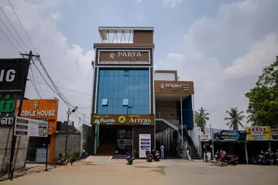 a building with motorcycles parked in front of it at Parva Residency in Palladam