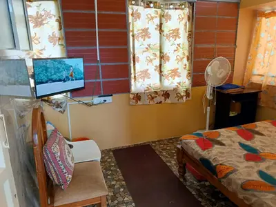 a room with a bed and a tv in it at Garden Room for a Couple in Mysore