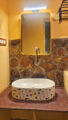 a bathroom sink with a large mirror above it at Rangers Nest Bandipur in Gundlupet