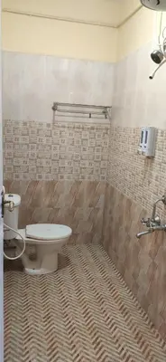 a bathroom with a toilet and a sink at Nivriti Cottage Valley View Stay in Ooty