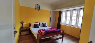 a bedroom with a bed and a window at Nivriti Cottage Valley View Stay in Ooty
