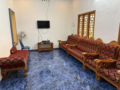 a living room with two couches and a tv at Munnar Wood valley in Munnar