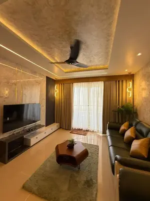 a living room with a couch and a tv at Bayfront Bliss - Flat 3BHK in Calicut Beach-Wakeup to stunning views in Kozhikode
