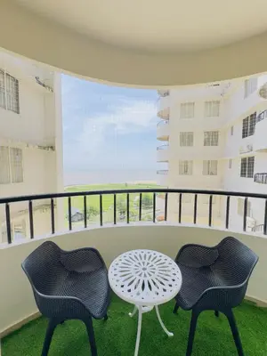 two chairs and a table on a balcony at Bayfront Bliss - Flat 3BHK in Calicut Beach-Wakeup to stunning views in Kozhikode