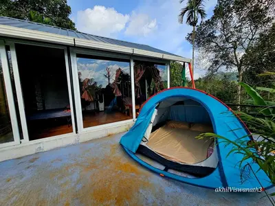 a blue tent sitting outside of a house at Valiyattu Nest Homestay in Ambalavayal