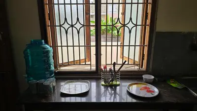 a window with plates and a bottle on a counter at Eden Garden Homestay in Mysore