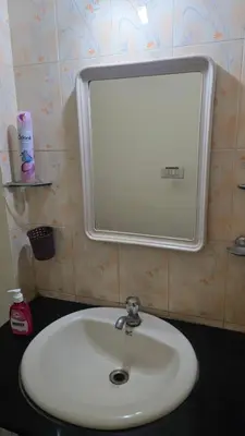 a white sink in a bathroom with a mirror at Eden Garden Homestay in Mysore