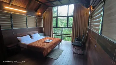 a bedroom with a bed in a room with windows at Fresh Wave Resort And Pool Villa Soochipara in Meppādi