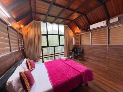 a bedroom with a large bed with a pink blanket at Fresh Wave Resort And Pool Villa Soochipara in Meppādi