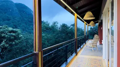 a balcony with chairs and a view of the mountains at Luxury Villa in Wayanad Hills with Private Garden in Wayanad