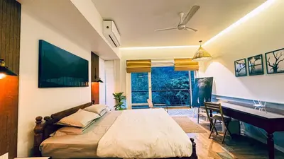 a bedroom with a bed and a desk and a piano at Luxury Villa in Wayanad Hills with Private Garden in Wayanad
