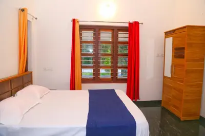 a bedroom with a bed with red curtains and a window at Whispering Streams in Tariyod
