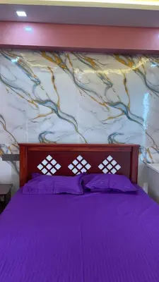 a bedroom with a purple bed with a wall at Yellow Bliss - 1BK Apartment in Coimbatore