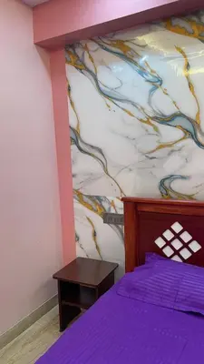 a bedroom with a purple bed with a painting on the wall at Yellow Bliss - 1BK Apartment in Coimbatore