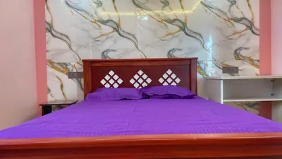 a bedroom with a purple bed with a wall at Yellow Bliss - 1BK Apartment in Coimbatore