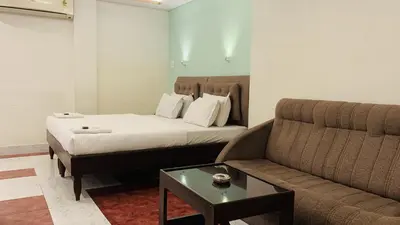 a hotel room with a bed and a couch at Hotel National Tourist Home in Trichūr