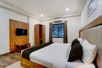a bedroom with a bed and a tv in it at Hotel O OZONE Residency in Kozhikode
