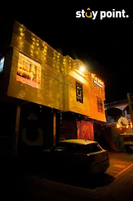 a building with a car parked in front of it at night at Stay Point Premium Capsule and Rooms in Calicut Beach in Kozhikode