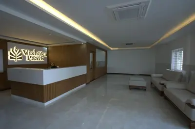 a lobby with a waiting room with a couch and a table at Hotel Vishaka Paark in Coimbatore