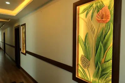 a hallway with paintings of flowers on the wall at Hotel Vishaka Paark in Coimbatore