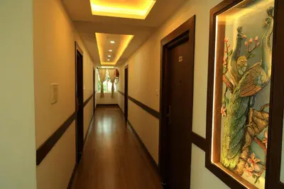 a corridor of a hallway with a painting on the wall at Hotel Vishaka Paark in Coimbatore