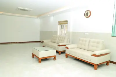 a living room with two couches and a coffee table at Hotel Vishaka Paark in Coimbatore
