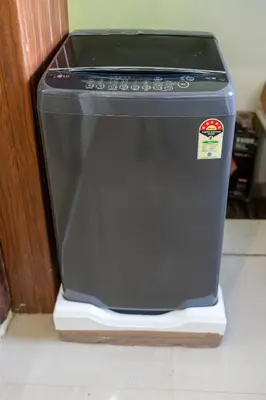 a black dishwasher sitting on the floor in a kitchen at CLUB 4 Homestay in Nedumbassery