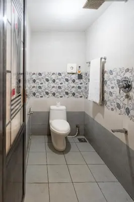 a bathroom with a white toilet and a shower at CLUB 4 Homestay in Nedumbassery