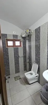 a bathroom with a toilet and a sink at Leela cottage in Kozhikode