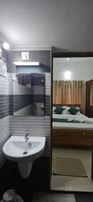 a bathroom with a sink and a bed at Leela cottage in Kozhikode