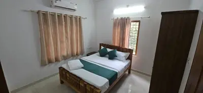 a bedroom with a bed and a window at Leela cottage in Kozhikode