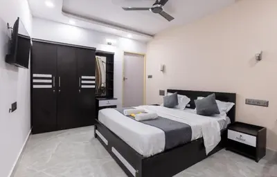 a bedroom with a large bed and a flat screen tv at Coorg Tranquil Retreat in Madikeri