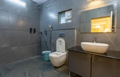 a bathroom with a sink and a toilet and a mirror at Coorg Tranquil Retreat in Madikeri