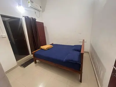a small bedroom with a blue bed in a room at Anugraha inn in Guruvāyūr