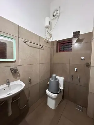 a bathroom with a toilet and a sink at Anugraha inn in Guruvāyūr