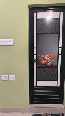 a black door with a bowl on a shelf at Anugraha inn in Guruvāyūr