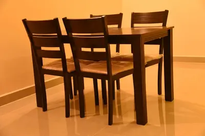 a wooden table with two chairs and a table at Daffodil serviced apartments in Mysore