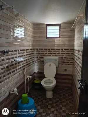 a small bathroom with a toilet in a room at Bhasuri AC Room 1 in Agali