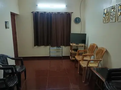 a room with chairs and a television and a curtain at Home away from home in Palakkad in Palakkad