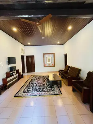 a living room with a couch and a table at Emnic Cottage Homestay in Meppādi