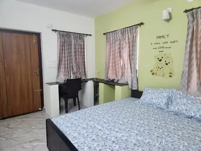 a bedroom with a bed and a desk at VPM Homestay in Coimbatore