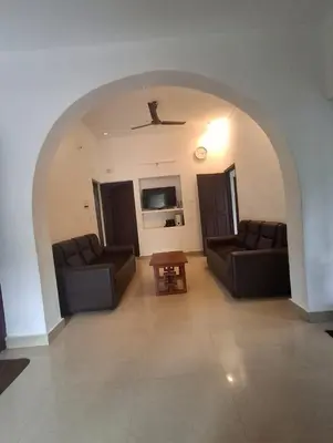a living room with two couches and a table at Winter Valley Homestay in Vythiri